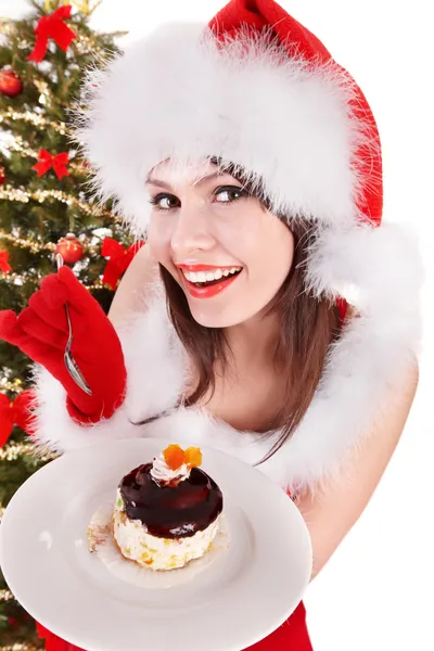 Weihnachtsmädchen mit Weihnachtsmütze und Kuchen auf Teller. — Stockfoto