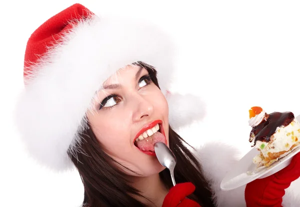Різдвяна дівчина в капелюсі Санта їсть торт на тарілці . — стокове фото