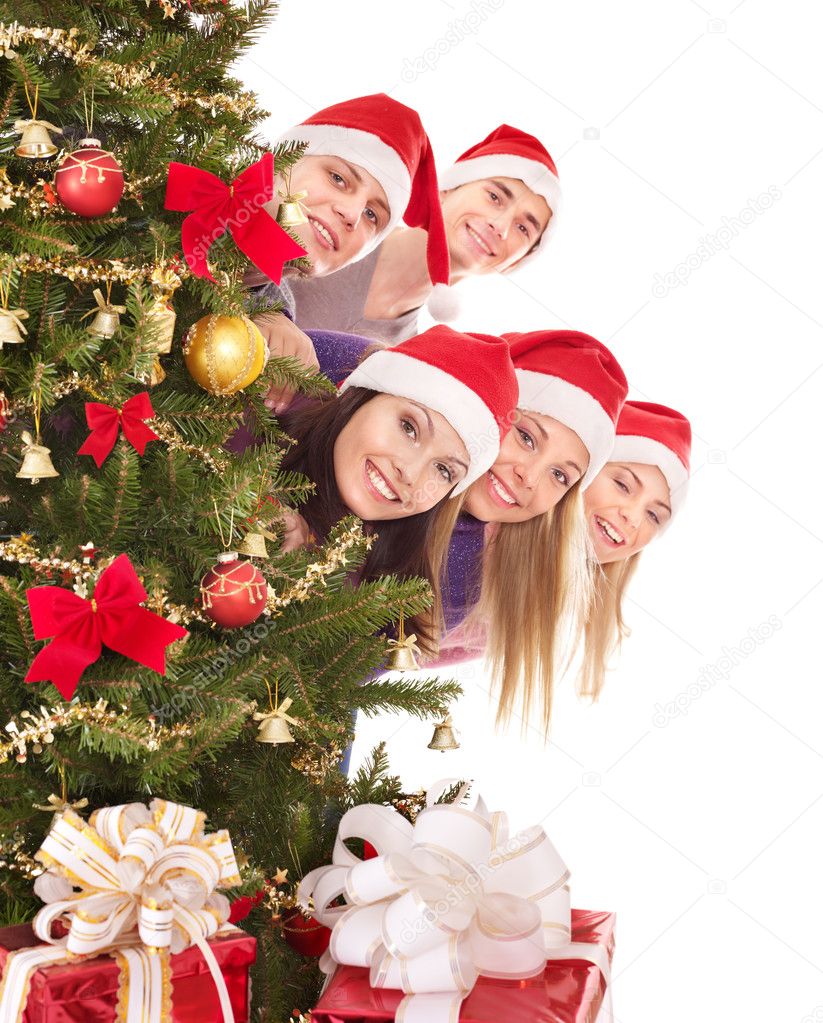 Group in santa hat by christmas tree.