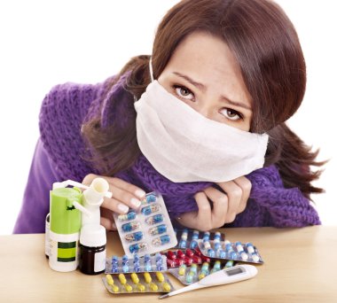 Girl having flu taking pills clipart