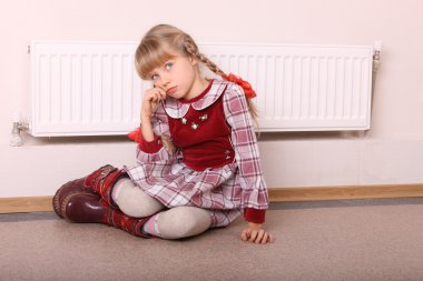 Girl warm near radiator. Crisis. clipart