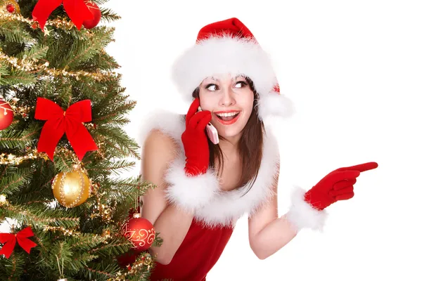 Menina em santa chapéu chamada telefone celular pela árvore de natal . — Fotografia de Stock
