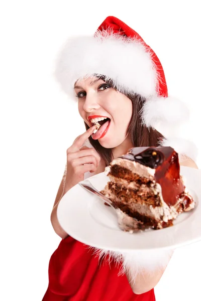 サンタ帽子でクリスマスの女の子がケーキを食べる . — ストック写真