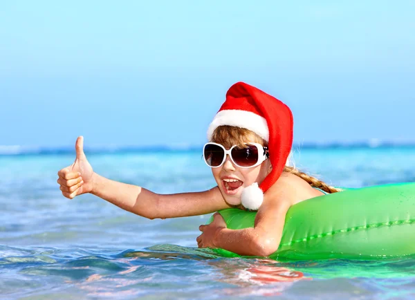 Şişme deniz ringde üzerinde yüzen Noel Baba şapkası, çocuk. — Stok fotoğraf