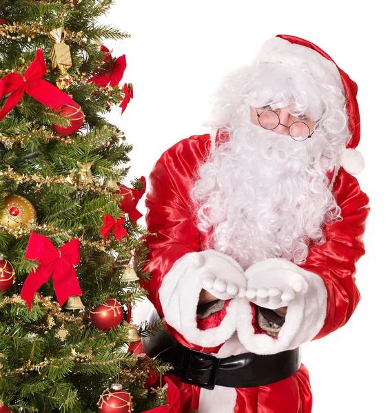 Santa claus door kerstboom. — Stockfoto