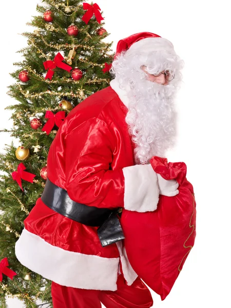 Weihnachtsmann trägt Sack am Weihnachtsbaum. — Stockfoto