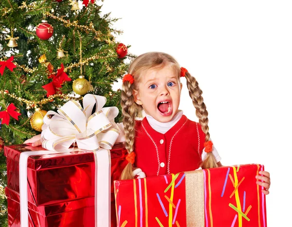Child giving gift box by christmas tree. — Stock Photo, Image