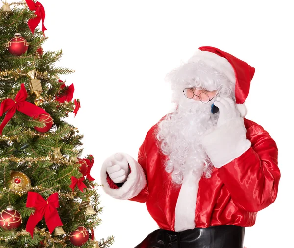 Santa claus door kerstboom duim omhoog. Rechtenvrije Stockfoto's