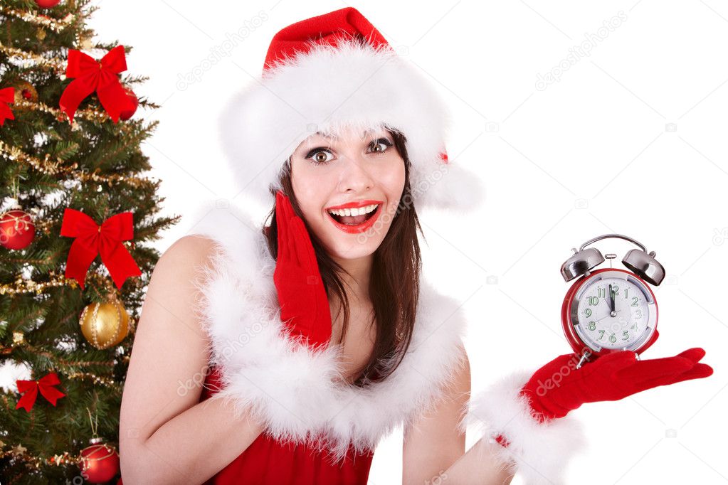 Girl in santa hat point on alarm clock .