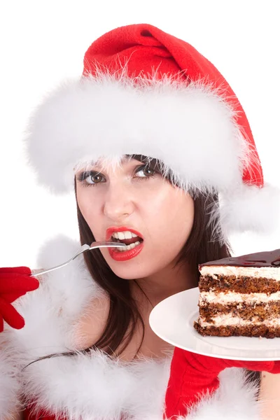 Weihnachtsmädchen mit Weihnachtsmütze und Kuchen auf Teller. — Stockfoto