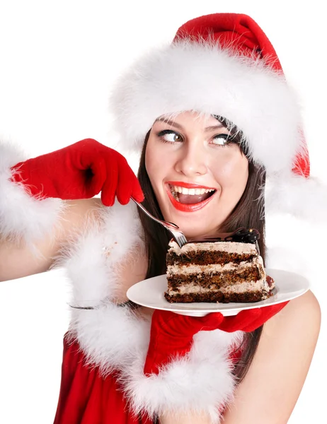 Weihnachtsmädchen mit Weihnachtsmütze essen Kuchen auf Teller. — Stockfoto
