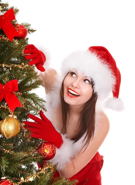 Girl in santa hat by christmas tree. Stock Picture