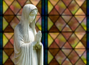 Isolated statue of Mary against window clipart