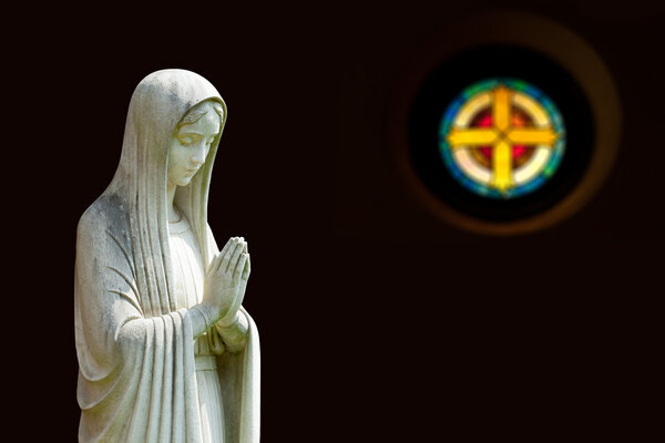 Isolated statue of Mary with cross