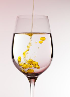 Olive oil being poured into wine glass clipart