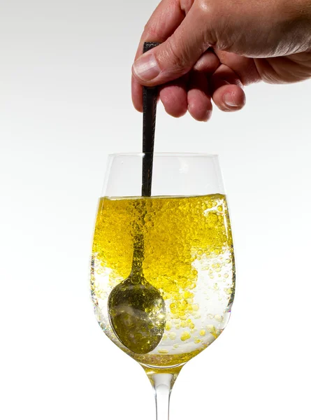 Olive oil being stirred in wine glass — Stock Photo, Image