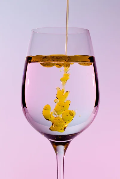 Aceite de oliva que se vierte en copa de vino — Foto de Stock