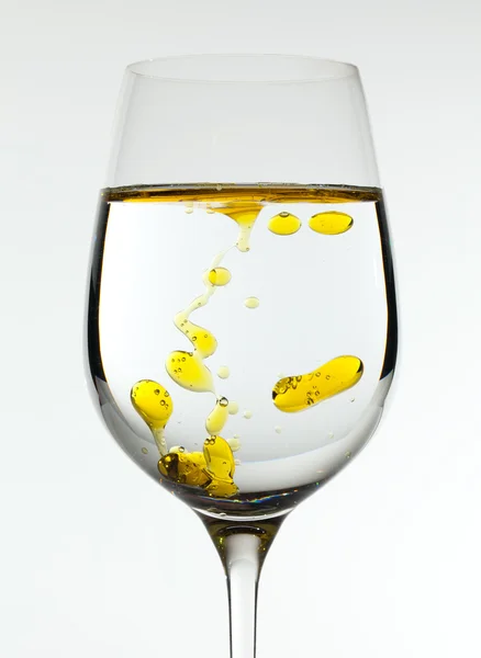 Aceite de oliva que se vierte en copa de vino —  Fotos de Stock