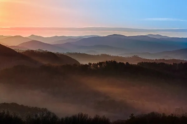 Dumanlı dağlar üzerinde gündoğumu — Stok fotoğraf