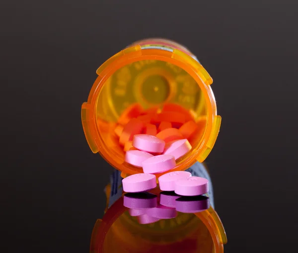 Fioletowe pigułki z butelka pomarańczowy narkotyków — Zdjęcie stockowe