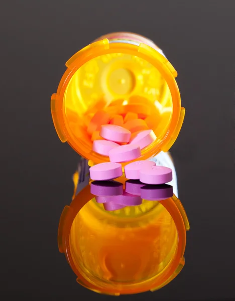 Pílulas roxas de garrafa de droga laranja — Fotografia de Stock