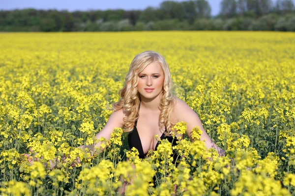 Alanındaki kır çiçekleri, sarışın güzel genç kadın. — Stok fotoğraf