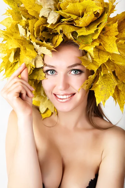 Uma menina com uma coroa de folhas de outono na cabeça . — Fotografia de Stock