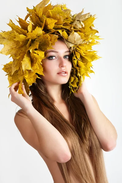 Девушка с венком из осенних листьев на голове . — стоковое фото