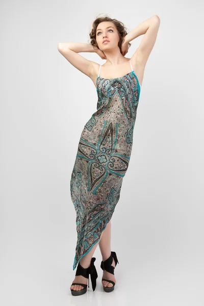 Schöne Frau posiert mit einem bunten Kleid. — Stockfoto