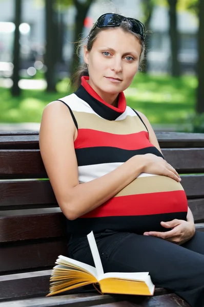 Leende gravid kvinna med bok — Stockfoto