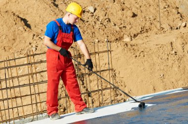 Builder worker at roof insulation work clipart