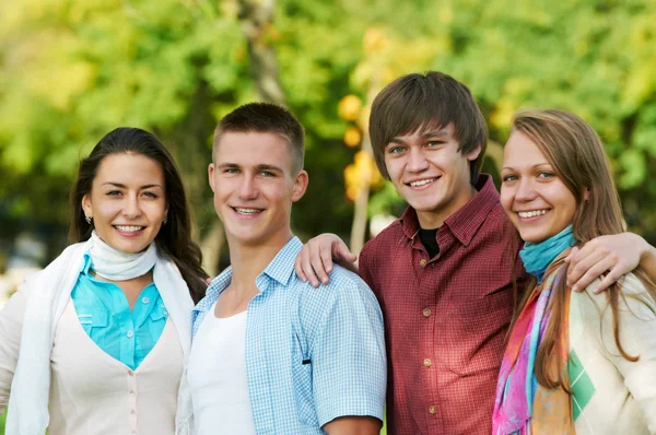 Groep van jonge studenten buiten glimlachen — Stockfoto