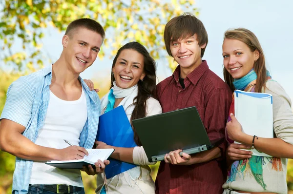 Группа улыбающихся молодых студентов на открытом воздухе — стоковое фото