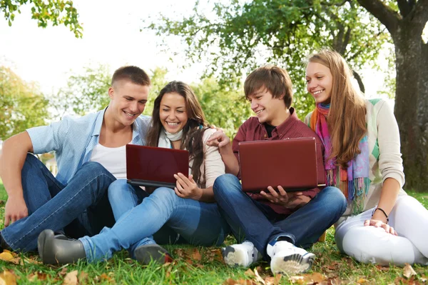 Groep van jonge studenten buiten glimlachen — Stockfoto