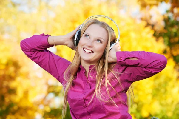 Žena se sluchátky na podzim venku — Stock fotografie