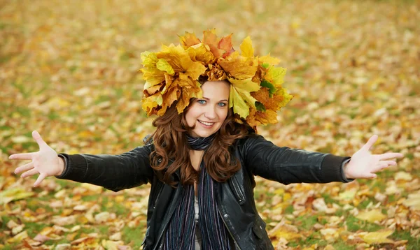 Woman with maple wreath at autumn outdoors — Stock Photo, Image