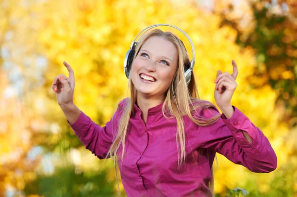 Žena se sluchátky na podzim venku — Stock fotografie