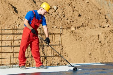 Builder worker at roof insulation work clipart