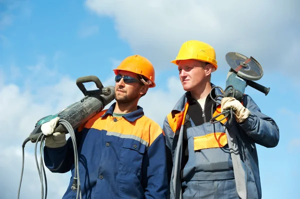 Werknemers in de bouw met machtshulpmiddelen — Stockfoto