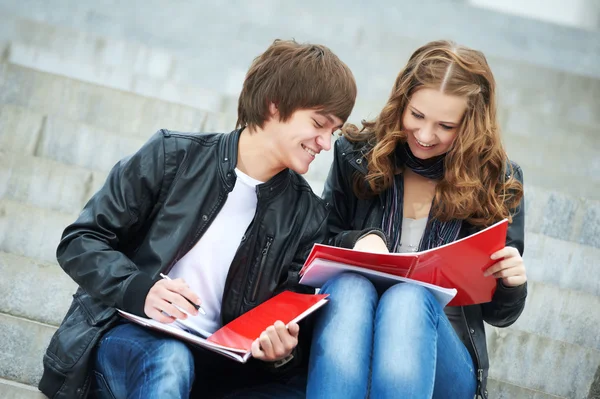 Δύο χαμογελώντας νέους φοιτητές που σπουδάζουν σε εξωτερικούς χώρους — Φωτογραφία Αρχείου