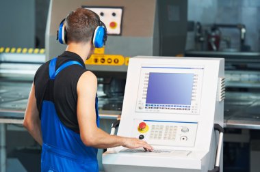 Worker operating cnc punch press clipart