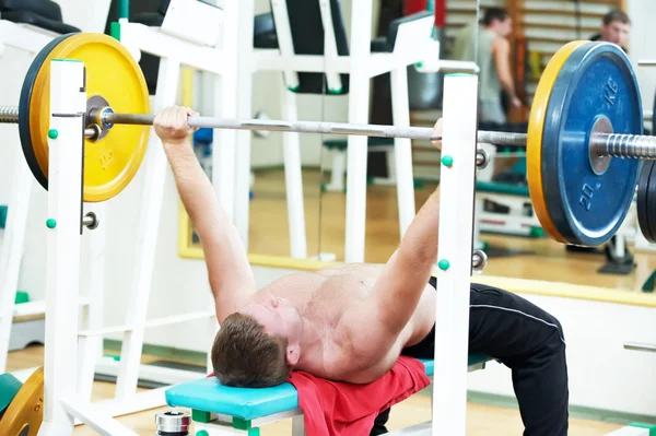 Culturista levantando peso en gimnasio deportivo —  Fotos de Stock