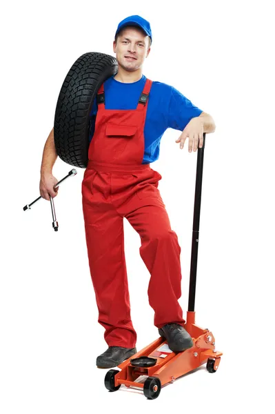 Reparador de automóveis com pneu e macaco de elevação — Fotografia de Stock