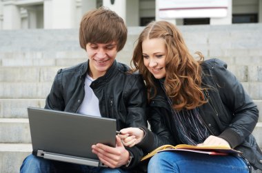 Two smiling young students outdoors