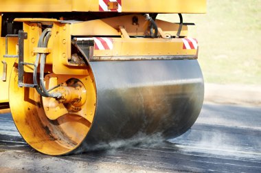 Compactor roller at asphalting work clipart