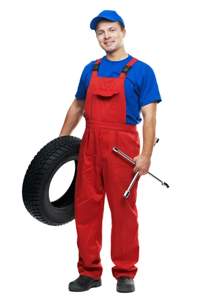 Automobilový mechanik s auto pneumatiky a klíč — Stock fotografie