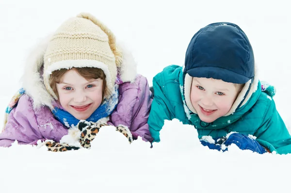Lachende gelukkige kinderen bij wintersneeuw buitenshuis — Stockfoto