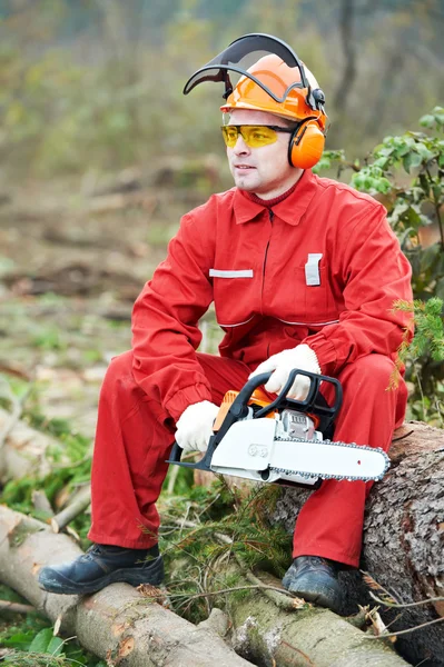 Pilarz pracownik z piłą łańcuchową w lesie — Zdjęcie stockowe