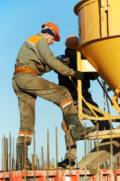 Byggnadsarbetare hälla betong i form — Stockfoto