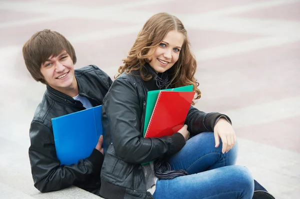 Två leende unga studenter som studerar utomhus — Stockfoto